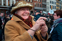Binche festival carnival in Belgium Brussels. Older woman taking pictures. Music, dance, party and costumes in Binche Carnival. Ancient and representative cultural event of Wallonia, Belgium. The carnival of Binche is an event that takes place each year in the Belgian town of Binche during the Sunday, Monday, and Tuesday preceding Ash Wednesday. The carnival is the best known of several that take place in Belgium at the same time and has been proclaimed as a Masterpiece of the Oral and Intangible Heritage of Humanity listed by UNESCO. Its history dates back to approximately the 14th century.